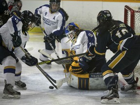 Windsor's Shawna Lesperance battles with Ryerson's Karli Nummikoski, left, in front of Ryerson goaltender Alex Armstrong in OUA women's hockey between the Windsor Lancers and the Ryerson Rams at South Windsor Arena, Friday, Jan. 15, 2016.  (DAX MELMER/The Windsor Star)