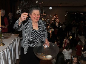 Julie Krickich tosses coins, walnuts, candy and wheat to children during Orthodox Christmas Eve or "badnje vece" at Serbian Community Centre Jan. 6, 2016.  Over 500 attended the celebration and banquet held by Serbian Orthodox Church Gracanica.  (NICK BRANCACCIO/Windsor Star)