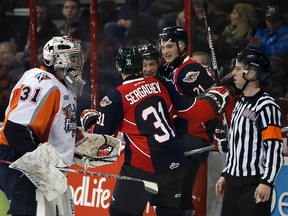 Windsor Spitfires Logan Brown, centre, celebrates his goal with teammates Brendan Lemieux and Mikhail Sergachev as Flint Firebirds goaltender Brent Moran, left, asks about interference on the play with referee in OHL action from WFCU Centre Jan. 21, 2016.  The goal put Windsor ahead, 1-0.