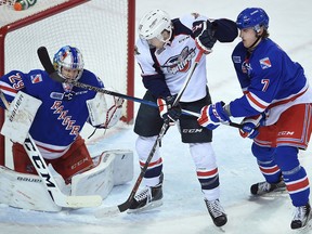The Kitchener Rangers host the Windsor Spitfires at The Aud in Kitchener, Ont. Jan. 29, 2016. Rangers goalie #29 Luke Opilka, left, makes a save as Spitfires player #19 Christian Fischer, centre, is ready to capitalize on a loose puck. Rangers player #7 Connor Hall, right, tries to check.