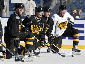 Boston Bruins players, from left, Landon Ferraro, Torey Krug, Alex Khokhlachev and Kevan Miller kneel on the ice during practice on the outdoor rink at Gillette Stadium in Foxborough, Mass., Thursday, Dec. 31, 2015, where the Bruins will play the Montreal Canadiens in the NHL Winter Classic hockey game on Friday. (AP Photo/Michael Dwyer)
