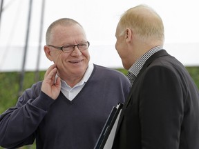 Pittsburgh Penguins NHL hockey team general manager Jim Rutherford, left, smiles as he talks to NHL executive Colin Campbell after the first day of general managers meeting in Boca Raton, Fla., Monday, March 16, 2015. (AP Photo/Alan Diaz)