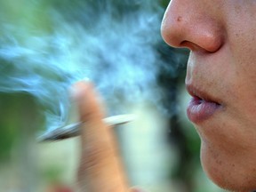A young man takes a hit from a marijuana cigarette in this May 2015 file photo. The Windsor Essex County Health Unit warns marijuana use may cause development damage to young people and is calling for it to be regulated like alcohol and tobacco.