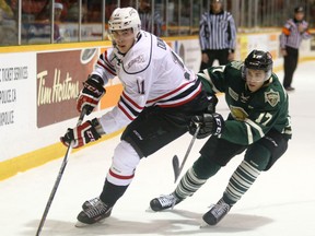 London Knights' Eric Henderson, right, chases the Owen Sound Attack's Liam Dunda into the corner as Dunda controls the puck during Ontario Hockey League first period action at the Lumley Bayshore in Owen Sound, Ont. on Saturday, December 19, 2015.  James Masters/Owen Sound Sun Times/Post Media Network