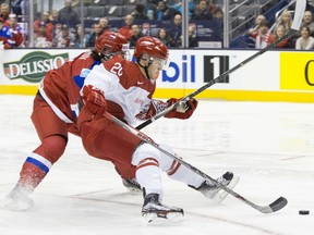 Russia's Ivan Provorov, left, battles for the puck with Denmark's Mads Eller during first period preliminary round action in the World Junior Hockey Championships in Toronto on Friday, December 26, 2014. THE CANADIAN PRESS/Chris Young