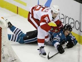 San Jose Sharks' Melker Karlsson, bottom, collides with Detroit Red Wings' Danny DeKeyser (65) during the first period of an NHL hockey game Thursday, Jan. 7, 2016, in San Jose, Calif. (AP Photo/Marcio Jose Sanchez)