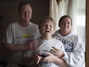 Matthew Abramson, 14, centre, is pictured with his parents, Mark and Stephanie Abramson, at their home in South Windsor, Wednesday, Dec. 16, 2015.  Abramson, who is a special needs child with autism, has been told not to come back to school at Holy Names Catholic High School.