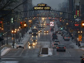 Vehicles make their way through downtown Flint, Mich., Thursday, Jan. 21, 2016.  Residents in the former auto-making hub — a poor, largely minority city — feel their complaints about lead-tainted water flowing through their taps have been slighted by the government or ignored altogether. For many, it echoes the lackluster federal response to New Orleans during Hurricane Katrina in 2005.