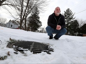 Brian Hopson is photographed next to a catch basin in front of his LaSalle home on Wednesday, Jan. 13, 2016. The town of LaSalle failed to receive funding for a project that would have solved flooding issues on the street.