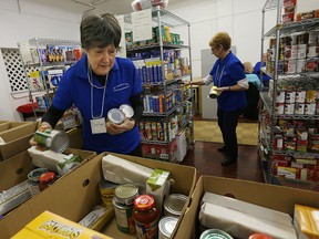 Volunteers Sharleen Robinet and Mary Dozzi load food boxes at the Divine Mercy Food Bank in Windsor.