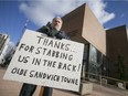 Patrick J. Mullin holds a sign he made expressing his displeasure with the school board's sale of the former Forster High School building to the Ambassador Bridge company, Saturday, Jan. 16, 2016.