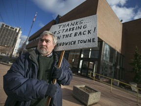 Patrick J. Mullin holds a sign he made expressing his displeasure with the school board's sale of the former Forster High School building to the Ambassador Bridge company, Saturday, Jan. 16, 2016.