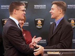 The Windsor and Essex County Crime Stoppers organization held a ceremony on Friday, January 29, 2016 to recognize the outgoing program manager and swear in the incoming individual. Tyler Lamphier (L) the incoming manager receives a ceremonial pair of handcuffs from Ron Funkenhauser, the outgoing manager during the event. (DAN JANISSE/The Windsor Star)