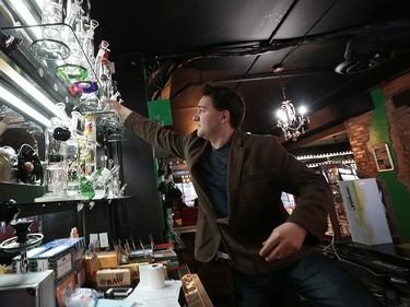 Higher Limits co-owner Jon Liedtke reaches for a bong inside the establishment at 251 Ouellette Ave.