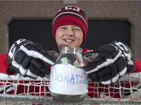 Jaxon Turnbull, 8, is pictured with donations he raised for his two-year-old cousin who was diagnosed with a brain tumour, Saturday, January 2, 2016.  Turnbull held a road hockey tournament over the holidays in order to raise the funds.