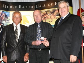 Dr. Joe Johnston, right, accepts the Canadian Horse Racing Hall of Fame ring for a A Worthy Lad in 2010 from Brian Tropea of the Ontario Harness Horse Association, centre, and Bud Fritz, the driver-trainer of A Worthy Lad.
