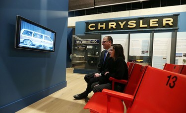 Drew Dilkens and his daughter Madison watch a video on the minivan at the Chimczuk Museum in Windsor on Thursday, Jan. 14, 2016.