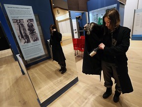 Madison Dilkens tries on smugglers coat at the Chimczuk Museum in Windsor on Thursday, Jan. 14, 2016.