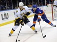 Nashville Predators' Ryan Ellis (4) and New York Islanders' Colin McDonald (13) chase the puck around the boards during the second period of an NHL hockey game on Tuesday, Nov. 12, 2013, in Uniondale, N.Y.