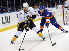 Nashville Predators' Ryan Ellis (4) and New York Islanders' Colin McDonald (13) chase the puck around the boards during the second period of an NHL hockey game on Tuesday, Nov. 12, 2013, in Uniondale, N.Y.