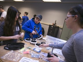 From left, Ariel Simpson, 14, Kaulin Baker, 16, and Hannah Iacobelli, 16, students from Cardinal Carter High School, take part in the FIRST Robotics Kick-Off Day at St. Clair College, Saturday, Jan 9, 2016.