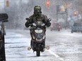 An e-biker cruises along College Avenue in Windsor, Ont. on Monday, Jan. 4, 2016, during snow flurries.