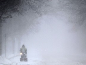 A man clears snow along Pillette Road during a winter storm in this January 2015 file photo.