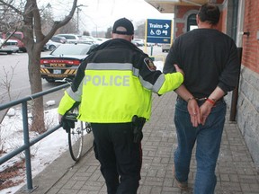 Cobourg police escort a Chatham-Kent man facing charges with uttering threats on a train from the Cobourg VIA Rail station to a waiting police cruiser.