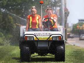 City of Windsor Parks and Recreation summer workers, Courtney Lauziere, 19, left, and Hilary Ryall, 19, try to stay cool as they drive through the sprinklers at Dieppe Park in downtown Windsor, in this June 2012 file photo.