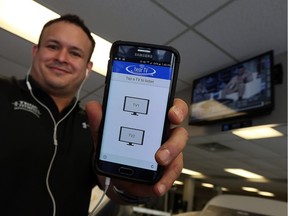 Luis Mendez is shows off the hearTV app at True Fitness in Windsor recently. The app allows people to listen to a muted television while working out.