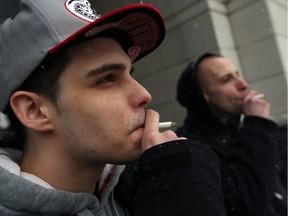 Jay Dee and Chris Larocque, right, smoke near city hall in Windsor on Wednesday, Jan. 20, 2016. Coun. Hilary Payne wants council to ban smoking at all city parks.