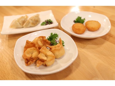 Patrons at Taka Japanese Sushi and Thai Food Restaurant are using the restaurant's iPads to order appetizers such as cheese wontons and gyoza (dumplings) and scallops (background).