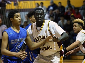 Catholic Central Comets' Jonathon Nicola, centre, defends against Kennedy Clippers' Omer Sulliman, left, in senior boys' high school basketball at Catholic Central high school gym on Tuesday, Jan. 5, 2016.