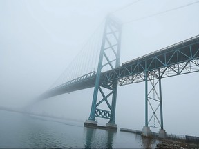 The Ambassador Bridge disappears into the fog over the Detroit River in this December 2015 file photo.