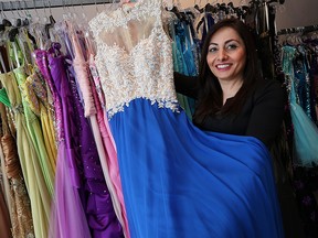 Marse Oraha, owner of Gabriela's Boutique, holds a dress at her shop in Windsor on Tuesday, January 12, 2016. Oraha plans to donate dresses for those who cannot afford a prom dress. (TYLER BROWNBRIDGE/The Windsor Star)