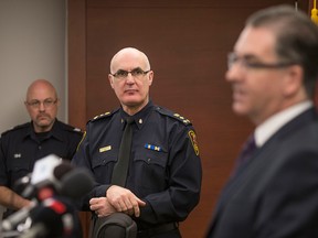 Sgt. Matt D'Asti, left, and Windsor Police Chief Al Frederick look on as MP Brian Masse speaks about the ongoing Canada Revenue Agency and immigration scams while at a press conference at Windsor Police headquarters, Friday, Feb. 12, 2016. (DAX MELMER/The Windsor Star)