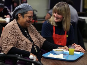 Downtown Mission visitor H. Lopez, left, shares a laugh with Rotary Club of LaSalle Centennial member Maria Price during dinner at Downtown Mission, February 23, 2016. Tuesday marked the 111th anniversary of Rotary International, and also marked the 11th anniversary of Rotary Club of LaSalle Centennial. (NICK BRANCACCIO/Windsor Star)