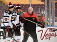 Head coach Joel Quenneville of the Chicago Blackhawks speaks with Dennis Rasmussen #70 and Erik Gustafsson #52 during practice day at the 2016 Coors Light Stadium Series on February 20, 2016 at TCF Bank Stadium in Minneapolis, Minnesota.