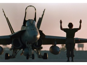 A Canadian CF-18 gets the go-ahead for takeoff at dusk at the military base in Dohar, Qatar on December 3, 1990.