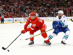 Detroit Red Wings defenseman Niklas Kronwall (55) keeps the puck from Vancouver Canucks right wing Brandon Prust (9) in the second period of an NHL hockey game Friday, Dec. 18, 2015 in Detroit.
