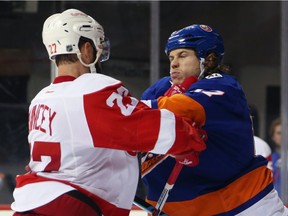 Kyle Quincey #27 of the Detroit Red Wings and Matt Martin #17 of the New York Islanders battle during the second period at the Barclays Center on January 25, 2016 in the Brooklyn borough of New York City.