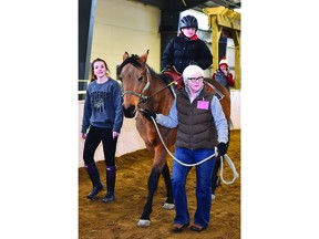 Volunteer Terri Hogan (right) leads while William, who has Down syndrome, rides the horse and volunteer Emily Hatton  helps. Erin Storey instructor/volunteer coordinator at Windsor-Essex Therapeutic Riding Association, checks on his progress from behind. - Ed Goodfellow photo