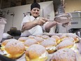 Anna Pare puts the finishing touches on a tray of paczki on Monday, Feb. 8, 2016, at the Lakeside Bakery in Leamington, Ont. A small army of workers were making over 1,000 paczki an hour in preparation for Fat Tuesday.