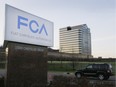 In this Tuesday, May 6, 2014, photo, a vehicle moves past a sign outside Fiat Chrysler Automobiles world headquarters in Auburn Hills, Mich.