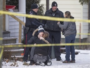 Two unidentified people embrace outside a house at 395 Curry Ave., where Windsor police are investigating a house fire, Saturday, February 13, 2016.