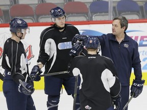 In this photo from Nov. 11, 2015, Flint Firebirds head coach John Gruden, talks with defencemen Josh Wesley, left, Hakon Nilsen, centre, and Vili Saarijärvi during a workout in Flint, Mich.