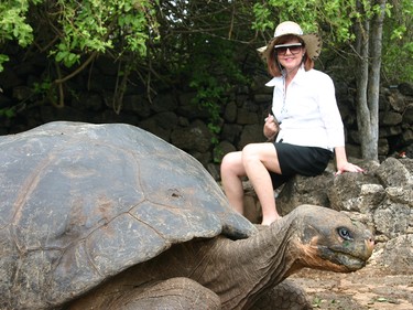 Theresa Dugal poses next to a giant turtle in the Galapagos islands, about 500 miles south of Ecuador, during her trip about eight years ago.- Courtesy Theresa Dugal