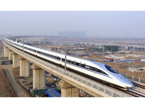 In this photo released by China's Xinhua news agency, a bullet train passes over Yongdinghe Bridge in Beijing Wednesday, Dec. 26, 2012. China has opened the world's longest high-speed rail line, which runs 2,298 kilometers (1,428 miles) from the country's capital in the north to Guangzhou, an economic hub in the Pearl River delta in southern China.