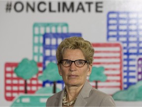Ontario Premier Kathleen Wynne listens to questions from the media during an announcement which outlined a cap and trade deal with Quebec aimed at curbing green house emissions, in Toronto on Monday, April 13 2015. The plan involves government-imposed limits on emissions from companies, and those that want to burn more fossil fuels can buy carbon credits from those that burn less than they are allowed.
