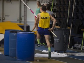 The Lancer track and field pole vault team practices around puddles and bins collecting water due to a leaky roof and heavy rain at the St. Denis Centre, Wednesday, Feb. 24, 2016. The Track and Field OUA Championships are being hosted by Windsor at the St. Denis Centre Feb. 26-28.